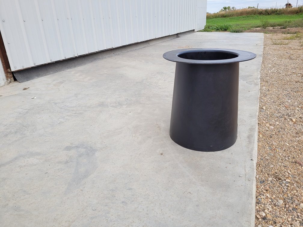 black plastic drink tube sitting on cement in front of shop